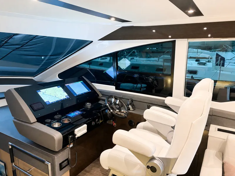Slide: The Image of The image shows the helm of a 2019 Cruisers Yachts 60 Fly with modern navigation systems. - 16