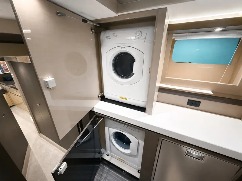 Slide: The Image of Interior of a 2019 Cruisers Yachts 60 Fly featuring a washer and dryer. - 48