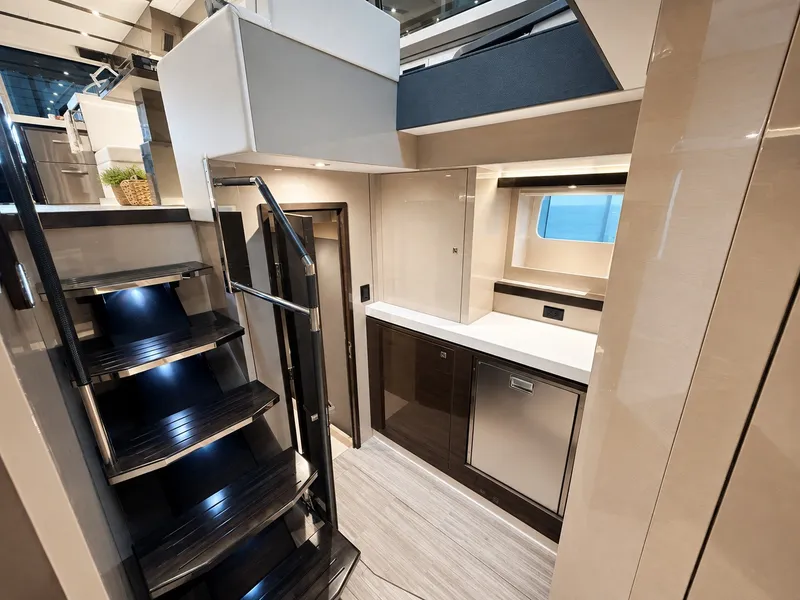 Slide: The Image of Interior of a 2019 Cruisers Yachts 60 Fly with sleek staircase and modern kitchen area. - 21