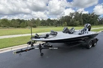 Slide: The Image of 2027 Nitro Z20 XL boat on trailer, parked on a paved road, under a cloudy sky. - 3