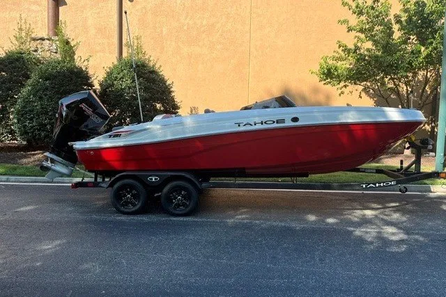 Slide: The Image of 2027 Tahoe T21 boat on trailer, red and white design, parked outdoors. - 1