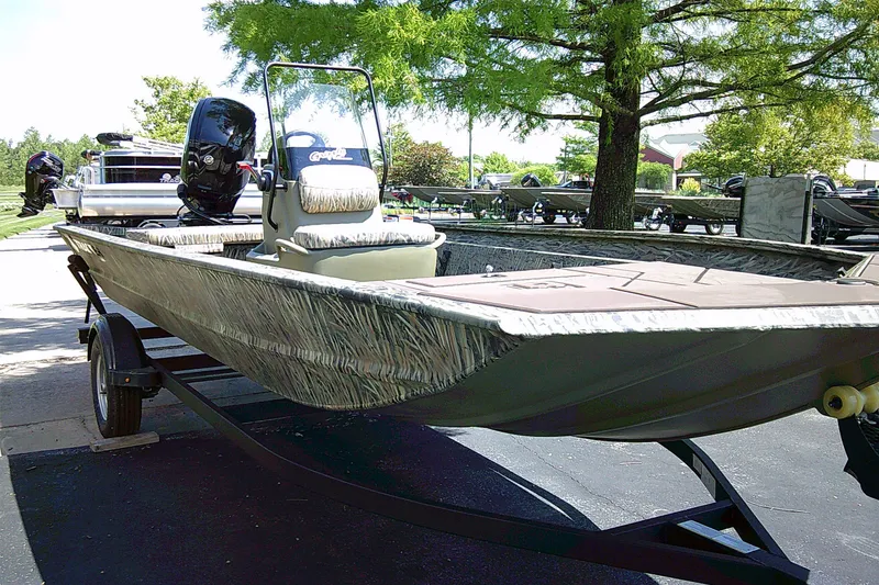 The Image of 2027 Tracker Grizzly 1860 CC boat on trailer, parked outdoors. - 0