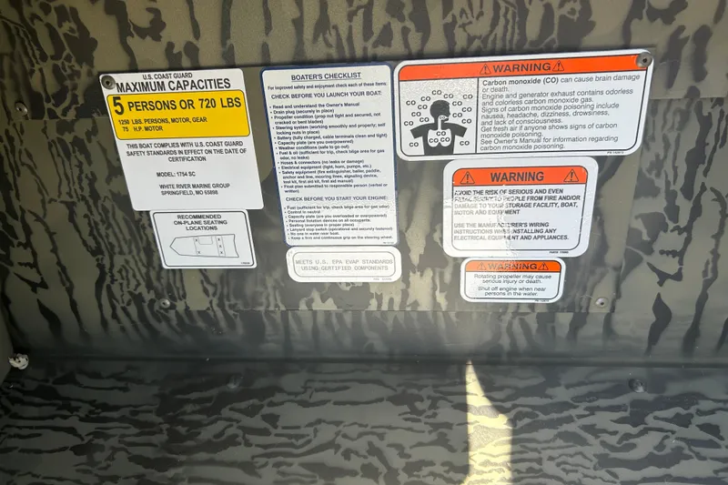 Slide: The Image of Safety and warning labels on a 2027 Tracker Grizzly 1754 SC boat interior. - 17