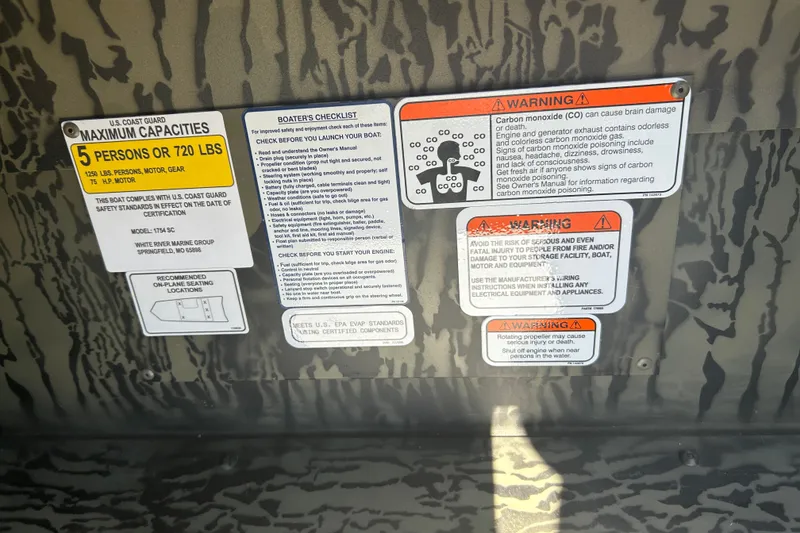 Slide: The Image of Safety and capacity labels on a 2027 Tracker Grizzly 1754 SC boat interior. - 16