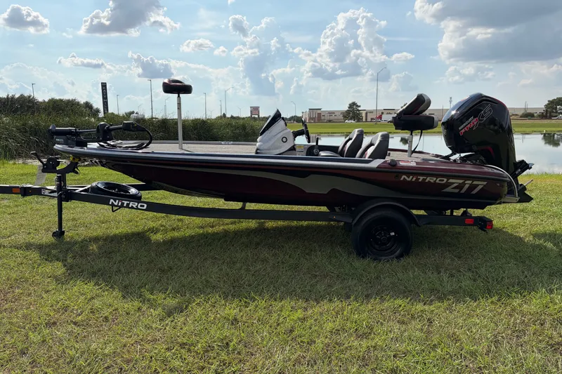 Slide: The Image of 2027 Nitro Z17 fishing boat on trailer, parked on grass near a lake under a cloudy sky. - 108