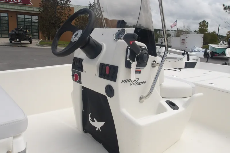 Slide: The Image of 2027 Mako Pro Skiff 17 CC boat console with steering wheel and controls. - 8