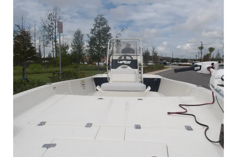 Slide: The Image of 2027 Mako Pro Skiff 17 CC boat with center console, parked outdoors under cloudy sky. - 14