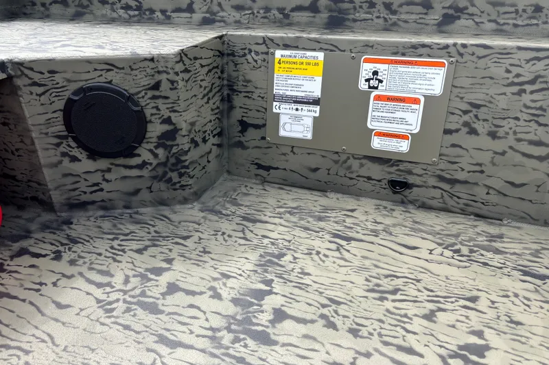 Slide: The Image of Interior of 2027 Tracker Grizzly 1650 T Prairie Wings Edition with camouflage design and safety labels. - 13