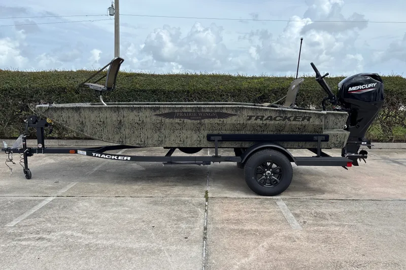 The Image of 2027 Tracker Grizzly 1650 T Prairie Wings Edition boat on trailer, parked outdoors. - 0