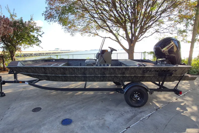 The Image of 2027 Tracker Grizzly 1860 CC boat on trailer, parked near waterfront under tree. - 0
