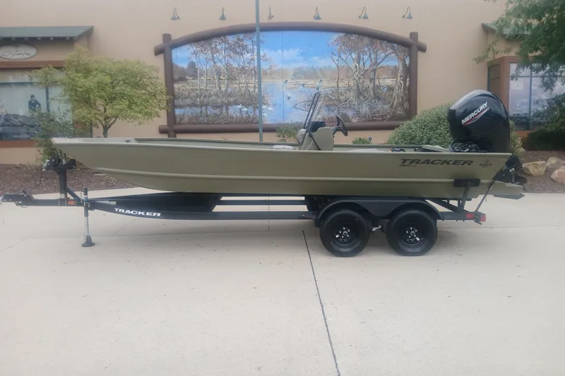 The Image of 2027 Tracker Grizzly 2072 CC boat on trailer, parked outdoors with scenic mural background. - 0