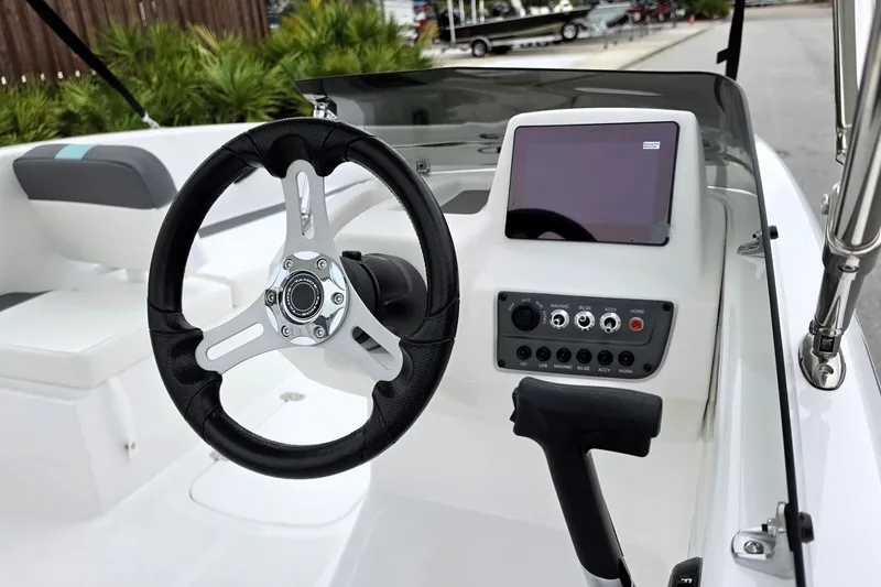 Slide: The Image of Steering wheel and dashboard of 2027 Tahoe T16 boat, featuring modern controls and display. - 15