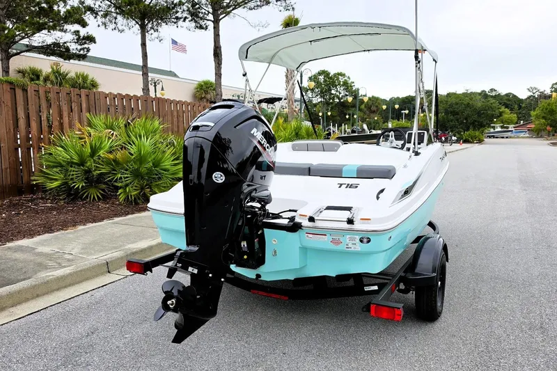 Slide: The Image of 2027 Tahoe T16 boat with outboard motor on trailer, parked on a street. - 4