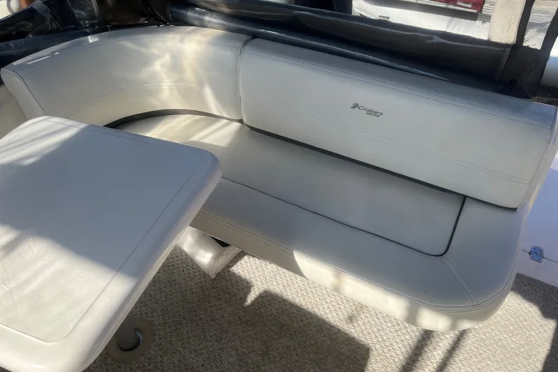 Slide: The Image of 2007 Cruisers Yachts 280 CXi Express interior seating with table, featuring white upholstery. - 17