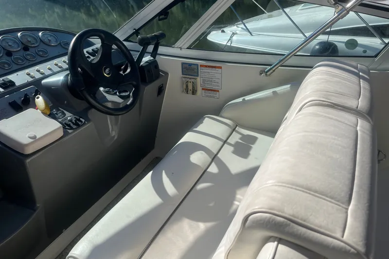 Slide: The Image of 2007 Cruisers Yachts 280 CXi Express cockpit with steering wheel and white seating. - 12