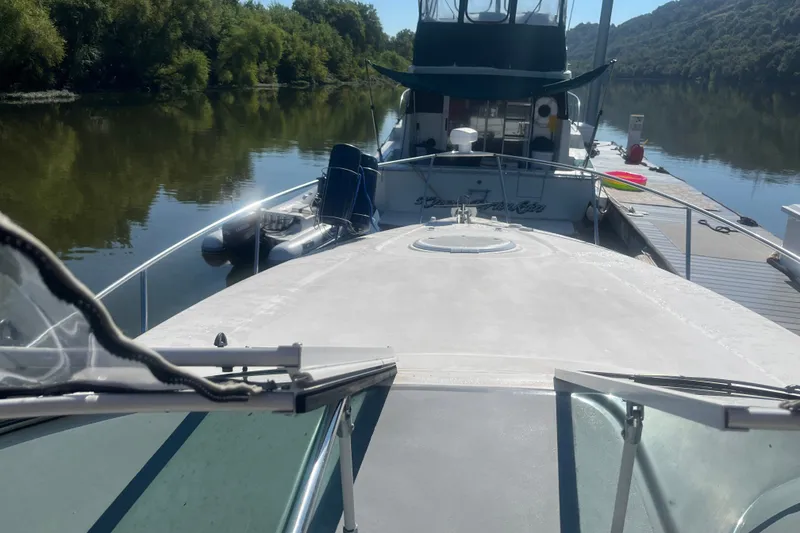Slide: The Image of 2007 Cruisers Yachts 280 CXi Express docked on a serene river with lush greenery. - 14
