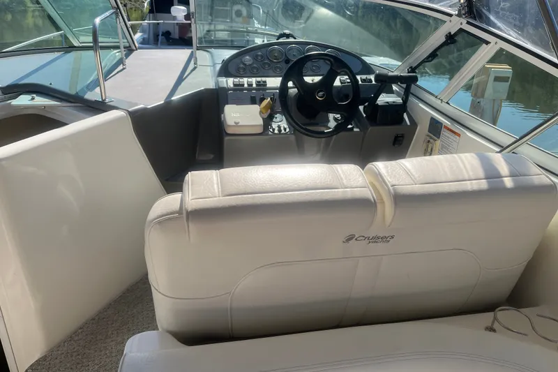 Slide: The Image of 2007 Cruisers Yachts 280 CXi Express cockpit with steering wheel and white seating. - 11