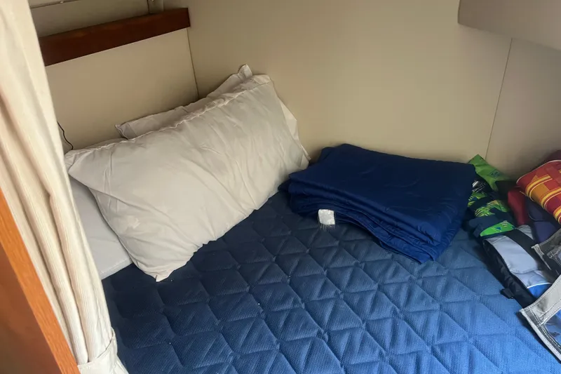 Slide: The Image of Cozy cabin bed in 2007 Cruisers Yachts 280 CXi Express with pillows and folded blankets. - 6