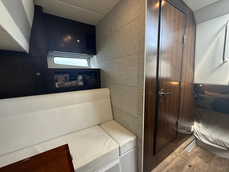 Slide: The Image of Interior of a 2021 Cruisers Yachts 42 GLS OB with white seating and wooden doors. - 29