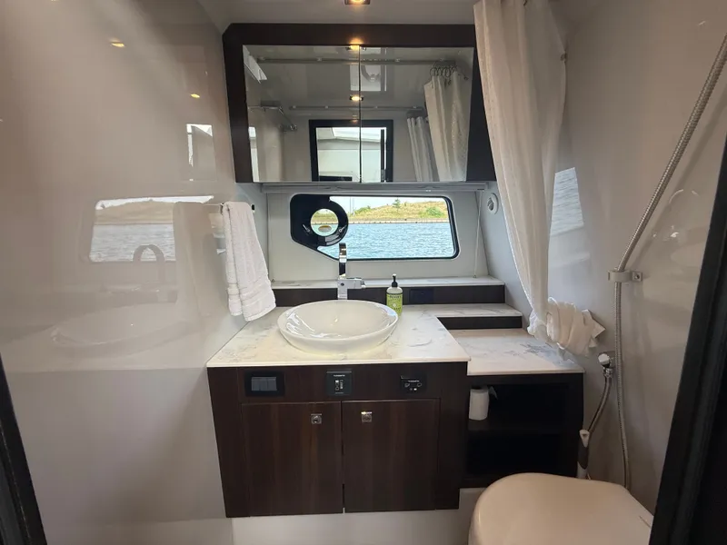 Slide: The Image of Luxurious yacht bathroom with a sink, mirror, and window overlooking the water. - 35