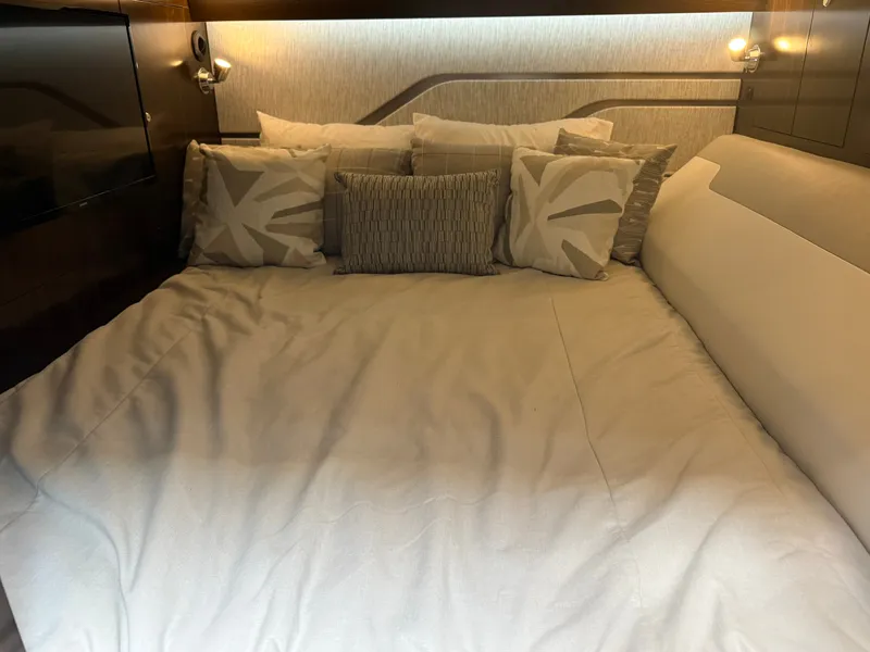 Slide: The Image of Luxurious bed in the cabin of the 2021 Cruisers Yachts 42 GLS OB, featuring elegant pillows. - 30