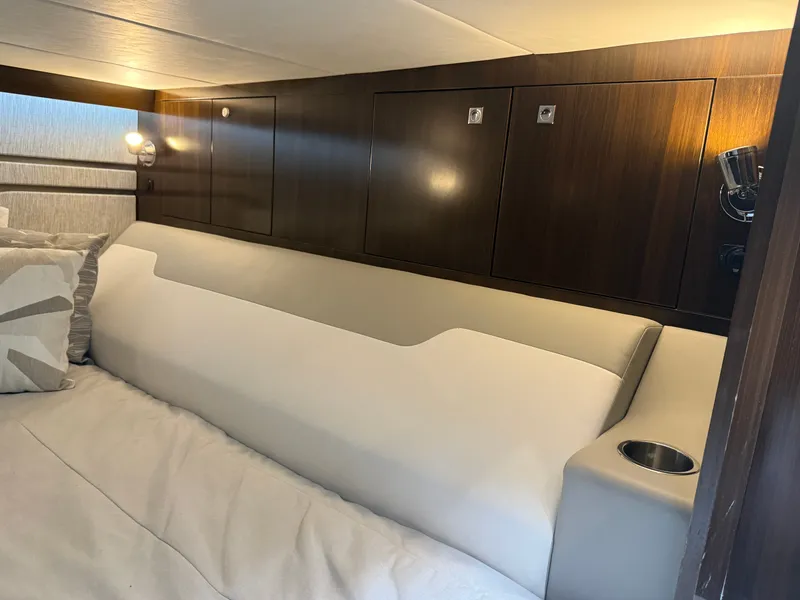 Slide: The Image of Interior of a 2021 Cruisers Yachts 42 GLS OB with sleek wood paneling and a comfortable bed. - 32