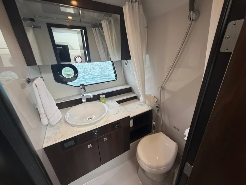 Slide: The Image of The image shows an elegant yacht bathroom with a sink, toilet, and shower. - 33