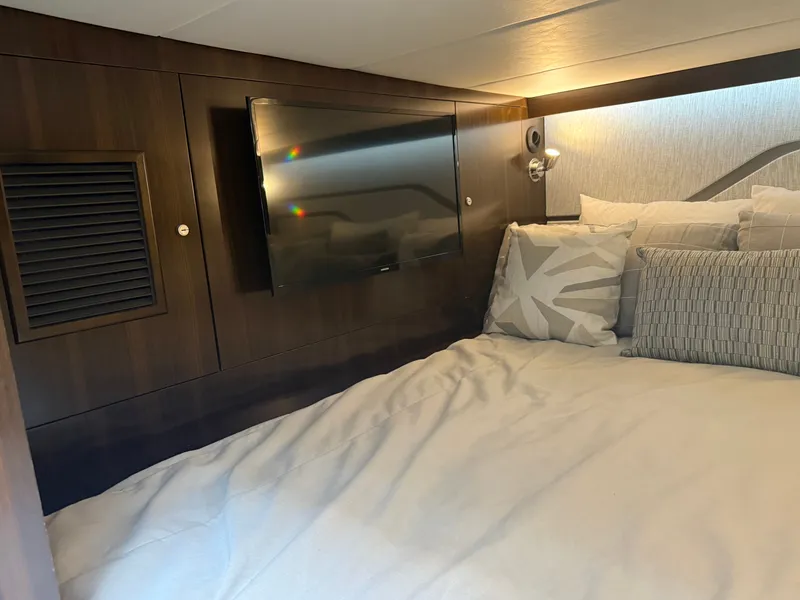 Slide: The Image of The cabin of the 2021 Cruisers Yachts 42 GLS OB features a cozy bed and a TV. - 31