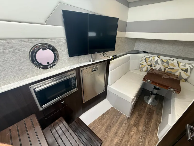 Slide: The Image of Interior of a 2021 Cruisers Yachts 42 GLS OB with seating area, table, TV, and microwave. - 23