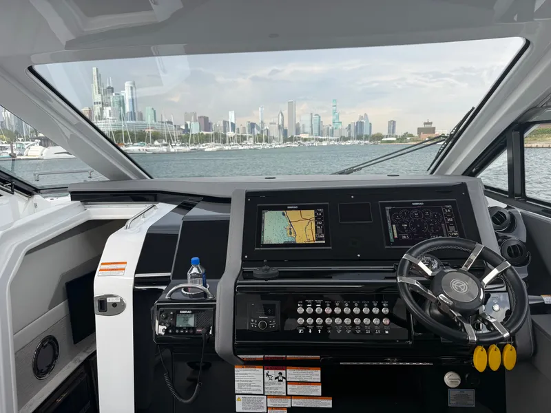 Slide: The Image of The cockpit of a 2021 Cruisers Yachts 42 GLS OB with a city skyline view. - 13
