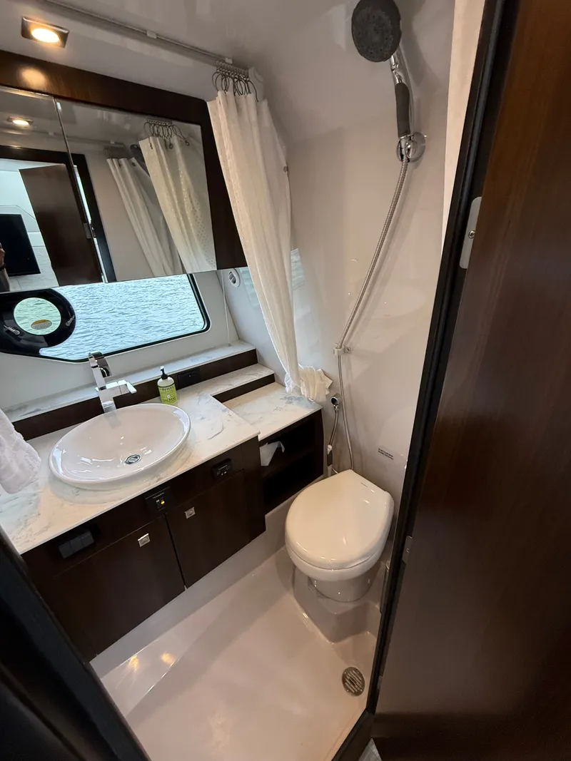 Slide: The Image of The image shows a modern yacht bathroom with a sink, toilet, and shower. - 34