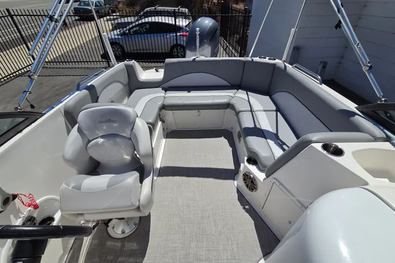 Slide: The Image of 2022 NauticStar 223 DC boat interior with gray seating and steering wheel. - 13