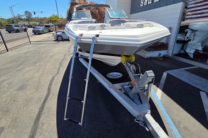 Slide: The Image of 2022 NauticStar 223 DC boat on trailer, parked outdoors near dealership. - 20