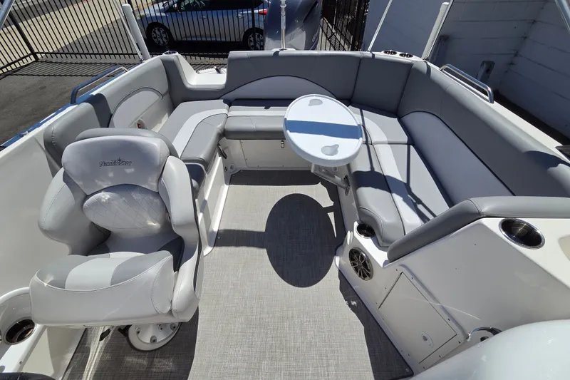 Slide: The Image of 2022 NauticStar 223 DC boat interior with gray seating and round table. - 14