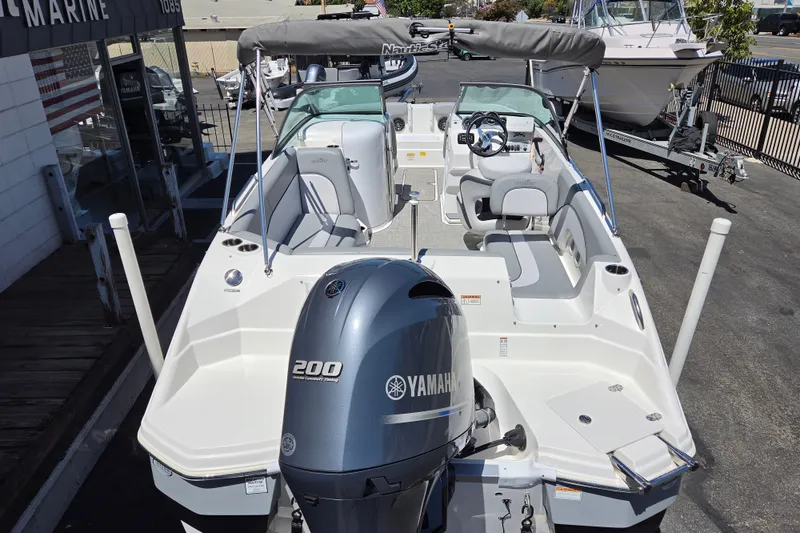 Slide: The Image of 2022 NauticStar 223 DC boat with Yamaha 200 engine, docked at a marina. - 23