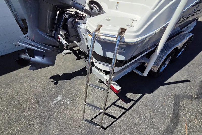Slide: The Image of 2022 NauticStar 223 DC boat with ladder and outboard motor on trailer. - 19