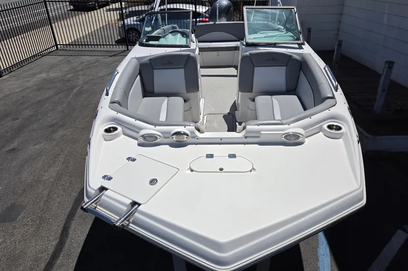 Slide: The Image of 2022 NauticStar 223 DC boat with spacious seating and sleek design in a marina setting. - 22