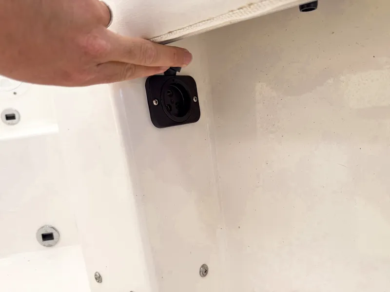Slide: The Image of Close-up of an electrical outlet on a boat, with a hand holding the plug. - 24