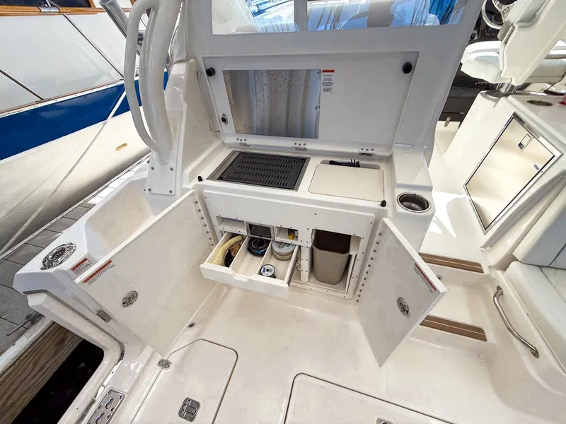 Slide: The Image of The 2026 Pursuit OS 325 Offshore features a well-equipped outdoor kitchen with storage and a sink. - 34