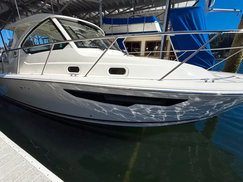Slide: The Image of A white boat docked at a pier, with a covered area in the background. - 9