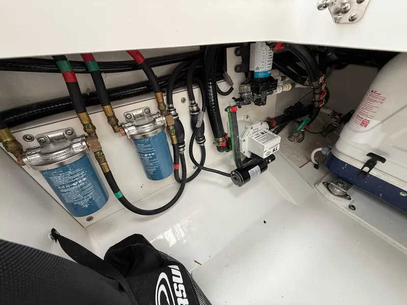 Slide: The Image of Engine compartment of the Pursuit OS 325 Offshore with filters and hoses. - 40