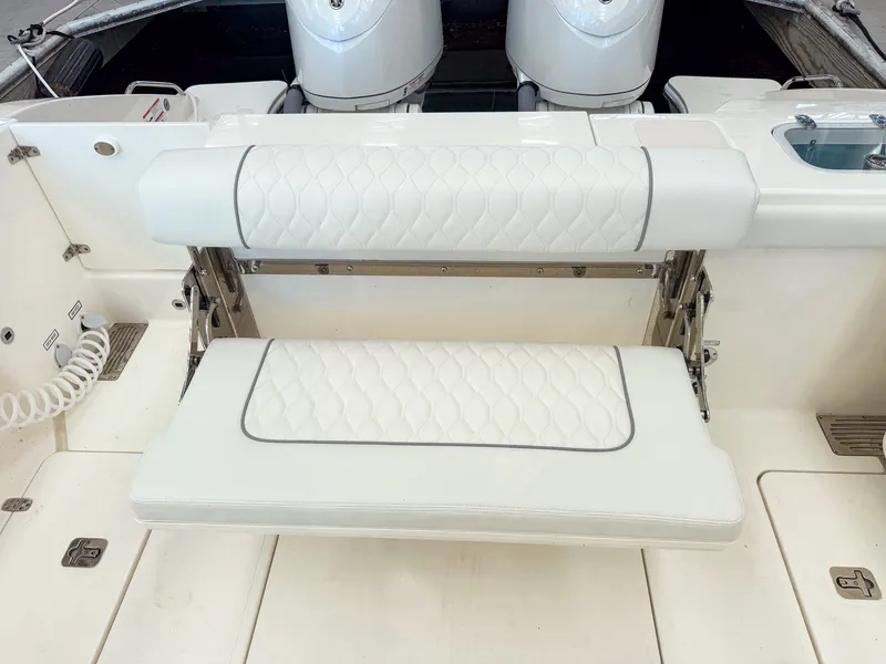 Slide: The Image of The rear bench seat of a 2026 Pursuit OS 325 Offshore with white upholstery and quilted pattern. - 28