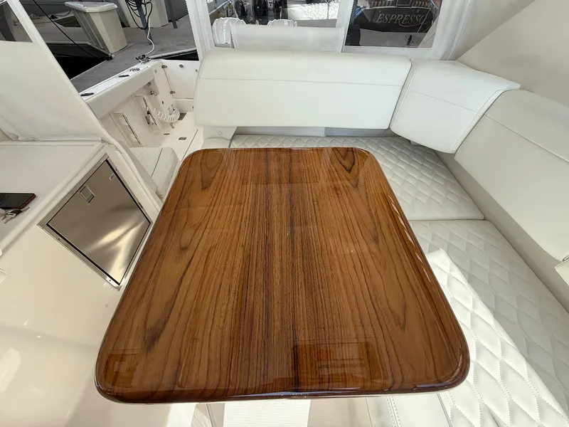 Slide: The Image of A sleek wooden table in a luxurious boat with white upholstery and stainless steel accents. - 48