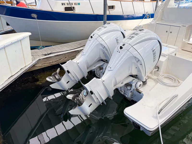 Slide: The Image of Two powerful outboard engines on a Pursuit OS 325 Offshore boat in a marina. - 1