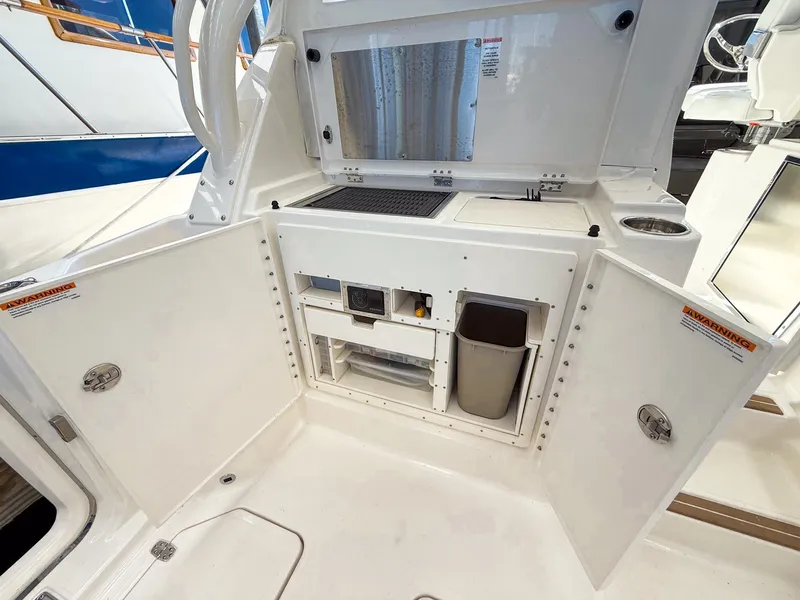 Slide: The Image of The 2026 Pursuit OS 325 Offshore features a well-equipped outdoor kitchen with storage and a sink. - 35