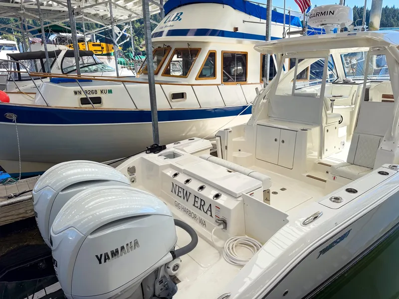 Slide: The Image of A Pursuit OS 325 Offshore boat with twin Yamaha engines, docked next to another boat. - 4