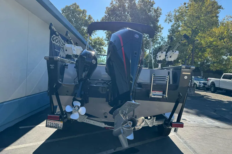 Slide: The Image of 2026 Lund 2075 Fisherman boat with dual outboard motors, parked outdoors. - 3