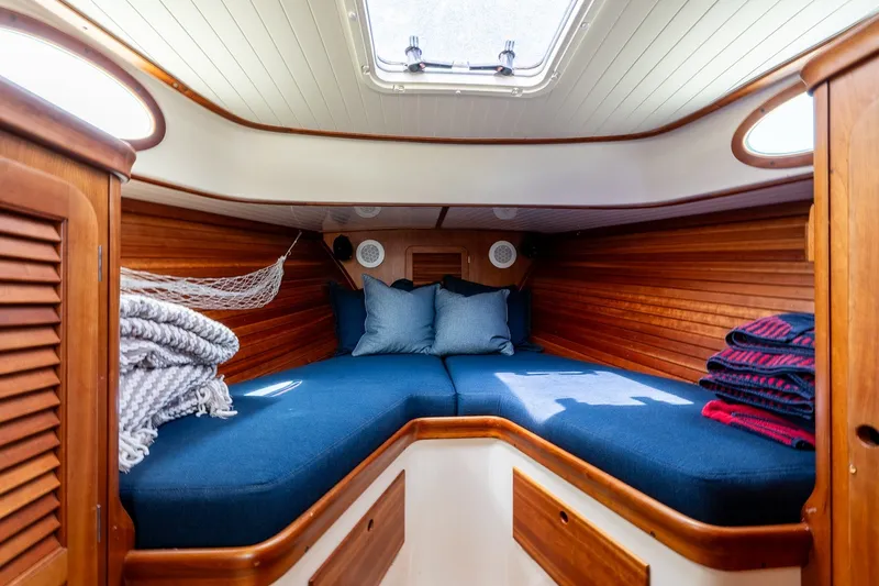 Slide: The Image of Cozy cabin interior of 2000 Hinckley Picnic Boat 36 Classic with blue cushions and wooden finish. - 25