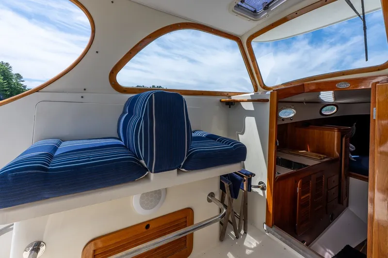 Slide: The Image of Interior of 2000 Hinckley Picnic Boat 36 Classic with blue striped seating and wooden accents. - 17