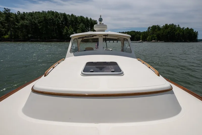 Slide: The Image of 2000 Hinckley Picnic Boat 36 Classic cruising on a serene lake with forested shoreline. - 11